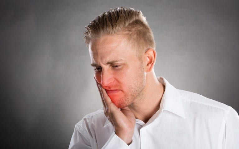 Man Holding Face In Pain